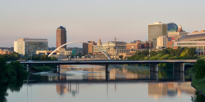 Downtown Des Moines, Iowa at sunrise with the Center Street pedestrian bridge over the river.