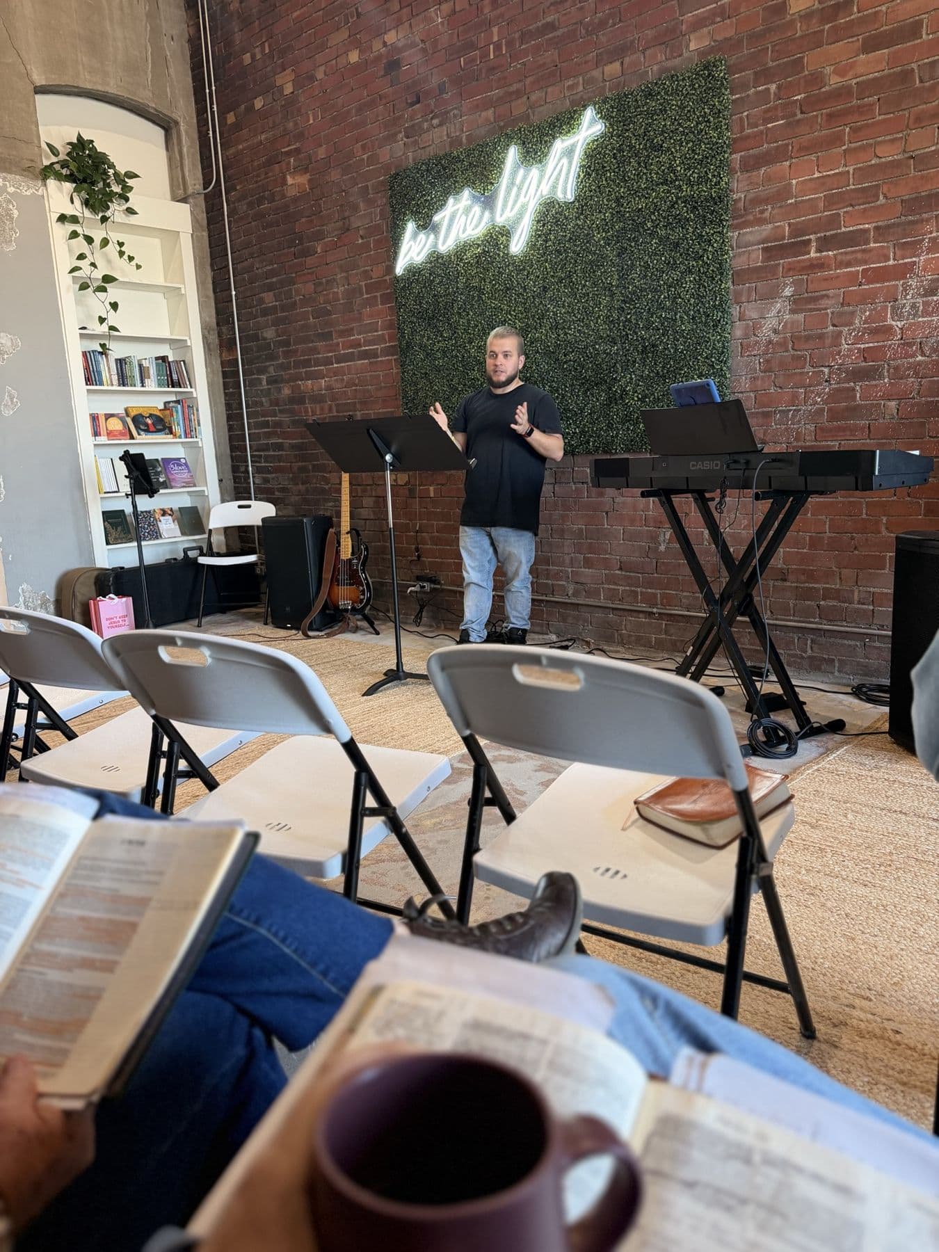 A Church For Pastors gathering in a brick-walled room, an open Bible and coffee in the foreground.